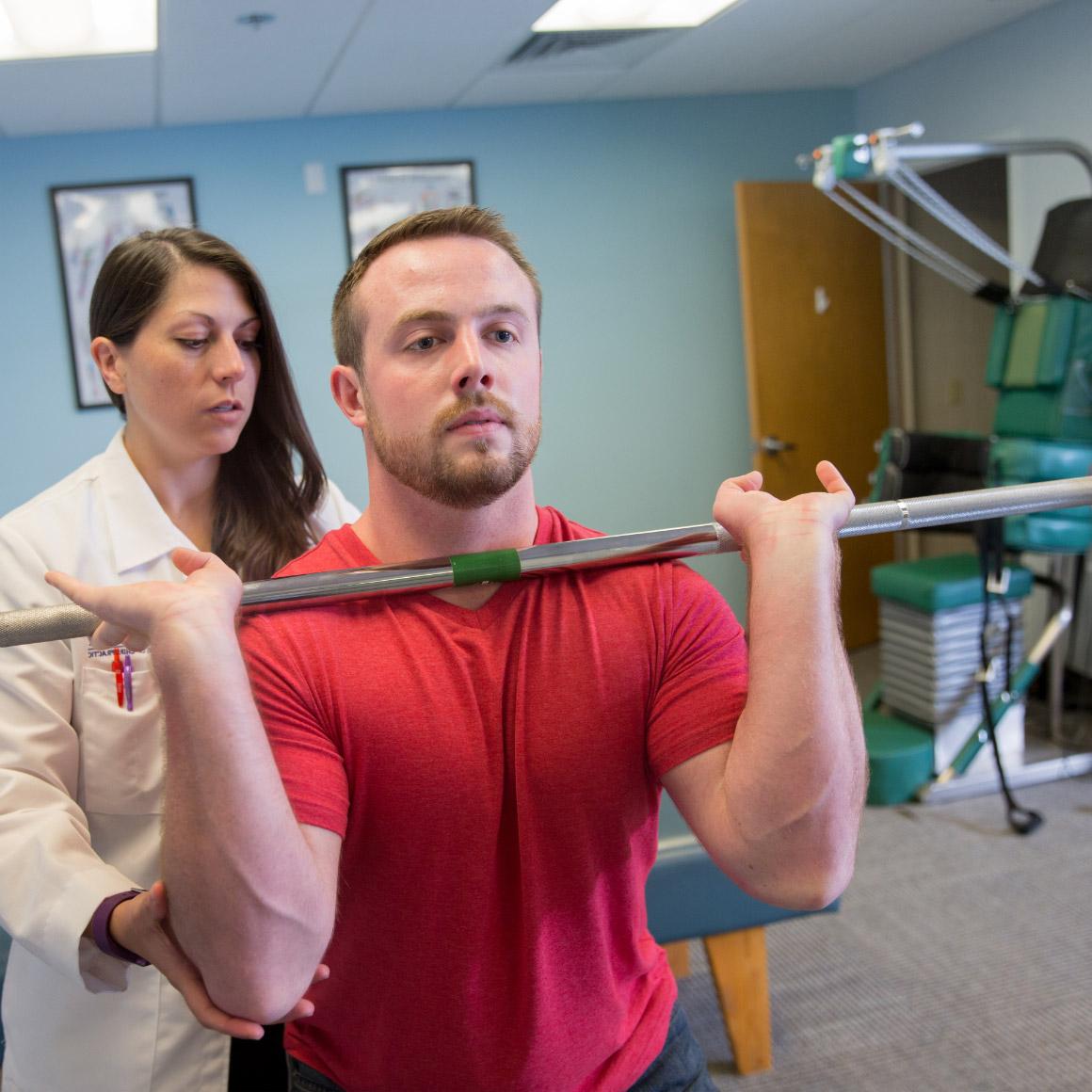 Student lifting weights with assistance